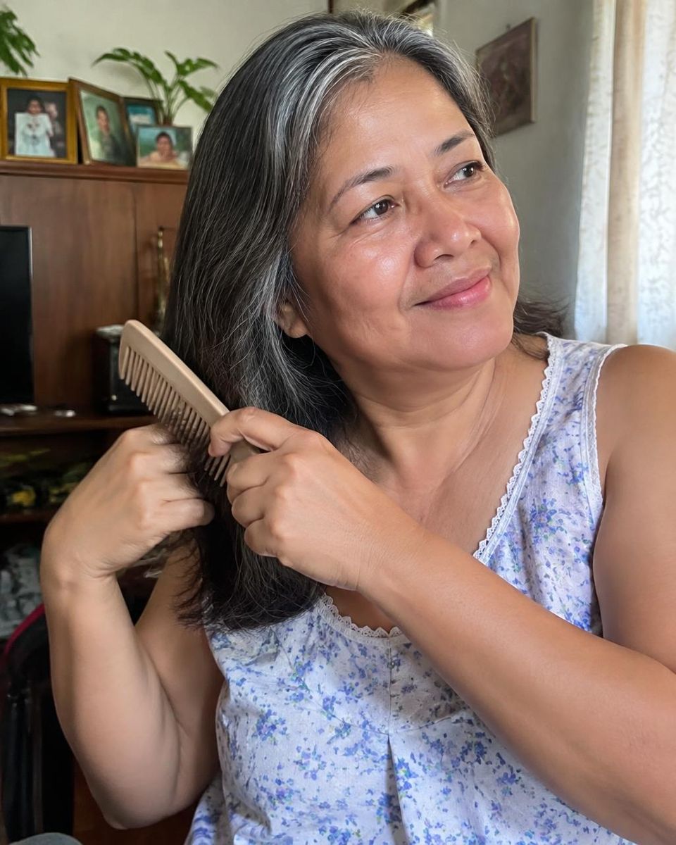 Mature Filipino woman combing her greying hair
